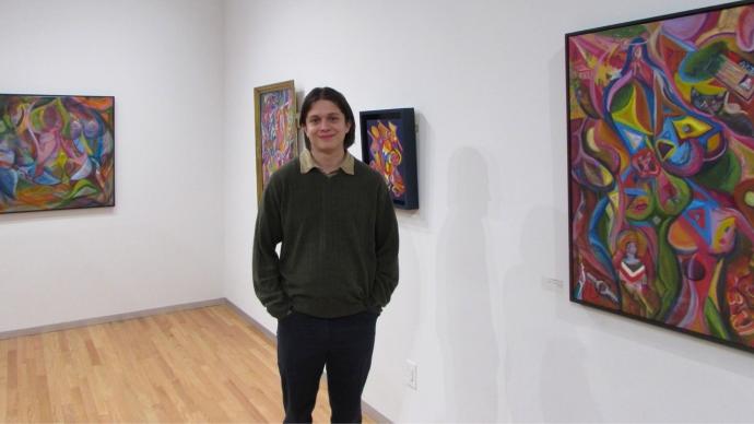 佩德罗·阿科斯塔站在画廊里展示他的作品
